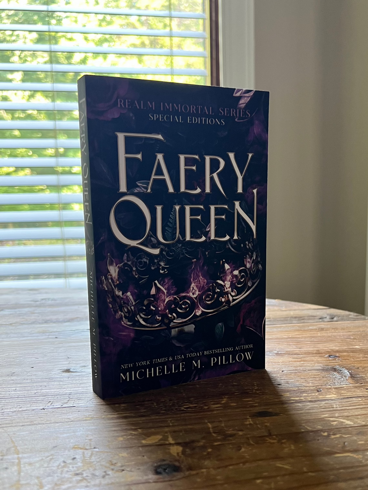 Faery Queen paperback book 2 upright on table.