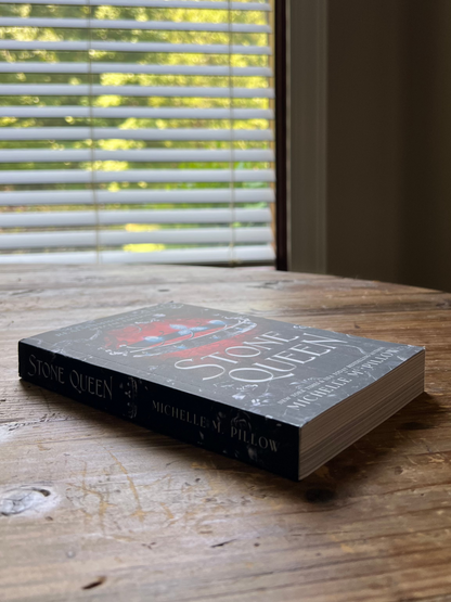 Stone Queen paperback laying flat on a table.