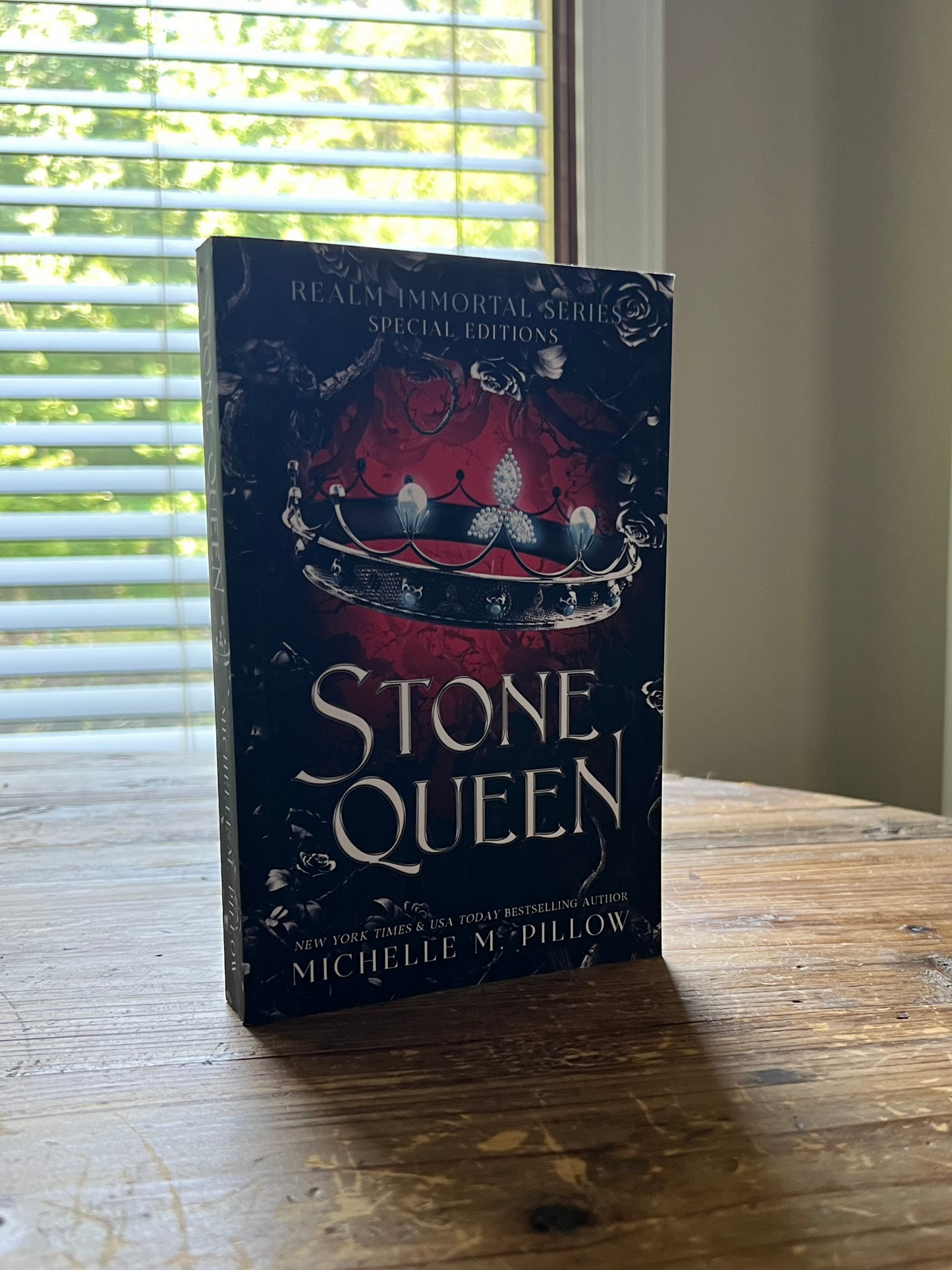 Stone Queen paperback standing upright on a table.