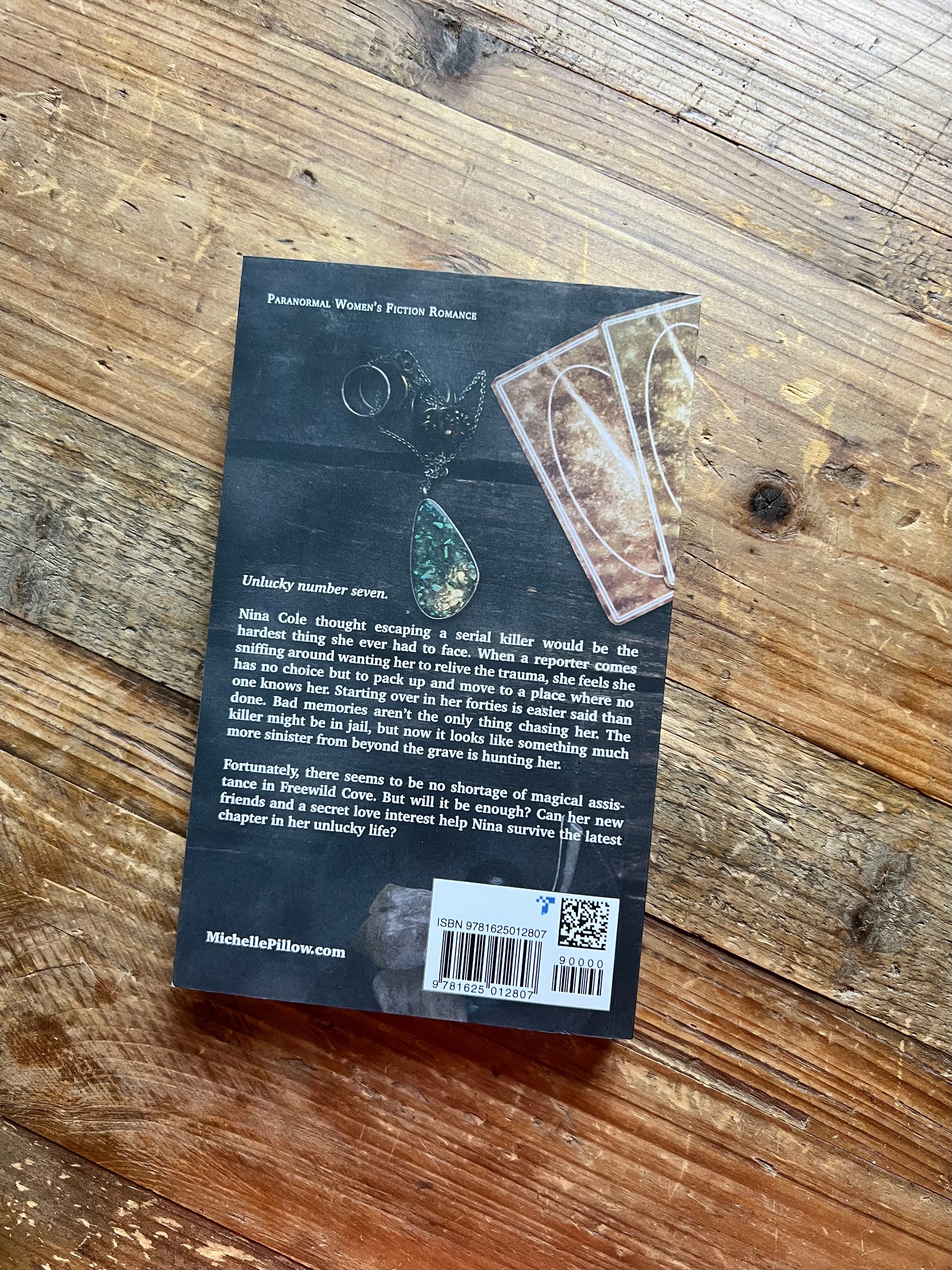 The Seventh Key paperback back cover on a table.