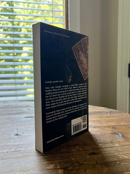 The Seventh Key paperback standing upright to show the back cover.