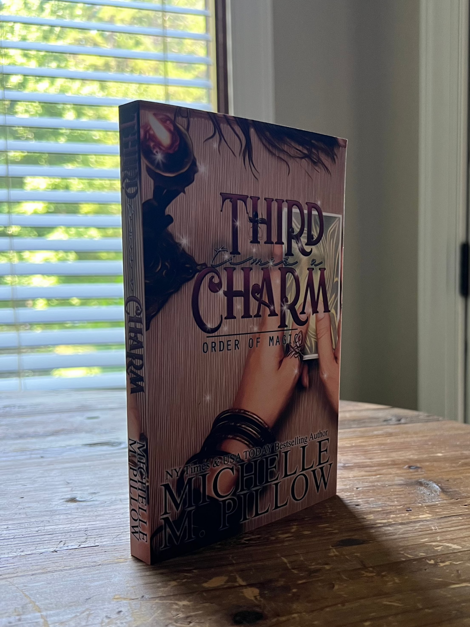 Third Time's a Charm paperback standing upright on a table.